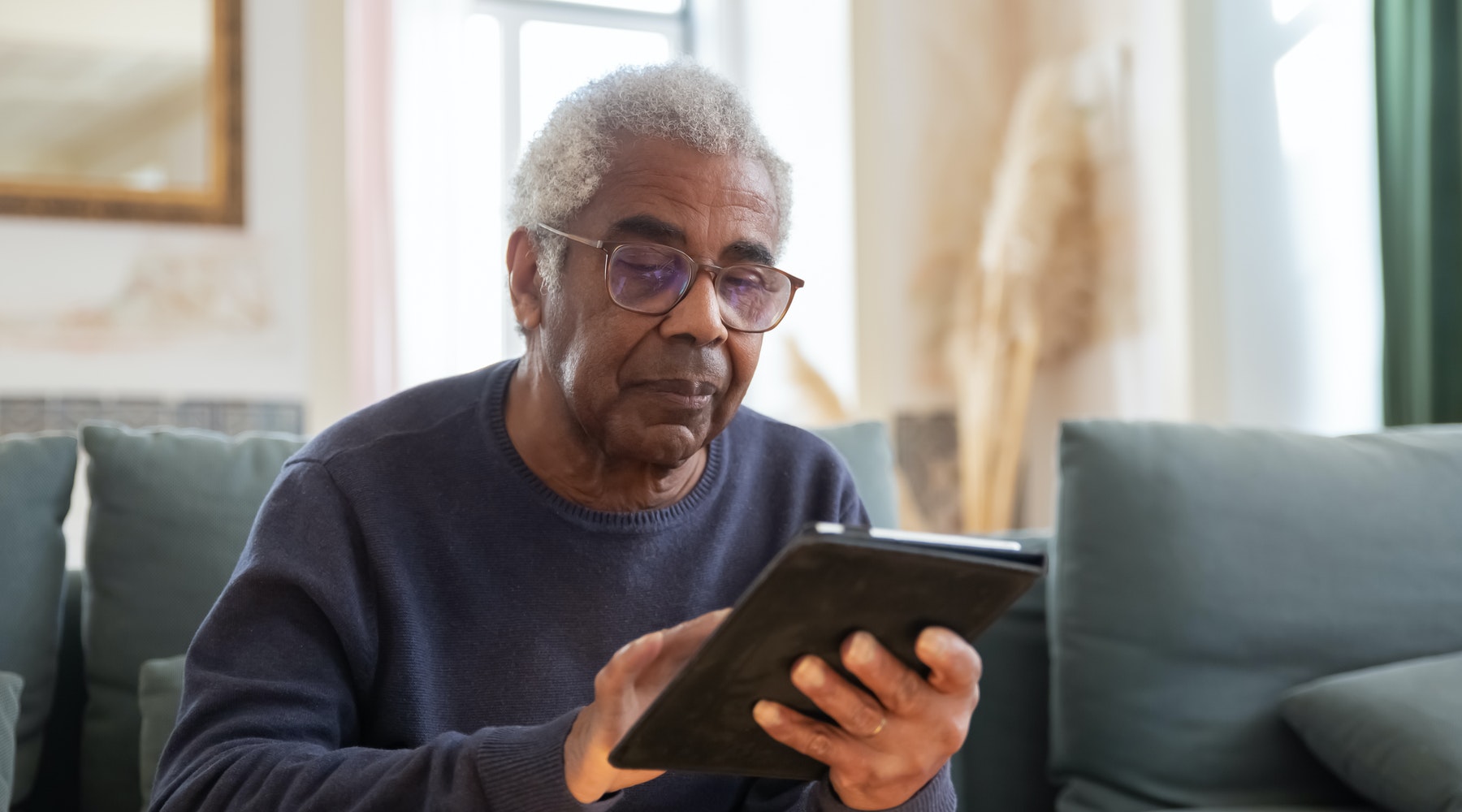 older man using a tablet at home