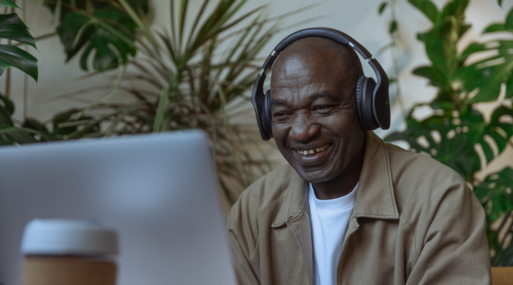 main smiling at computer while wearing headphones